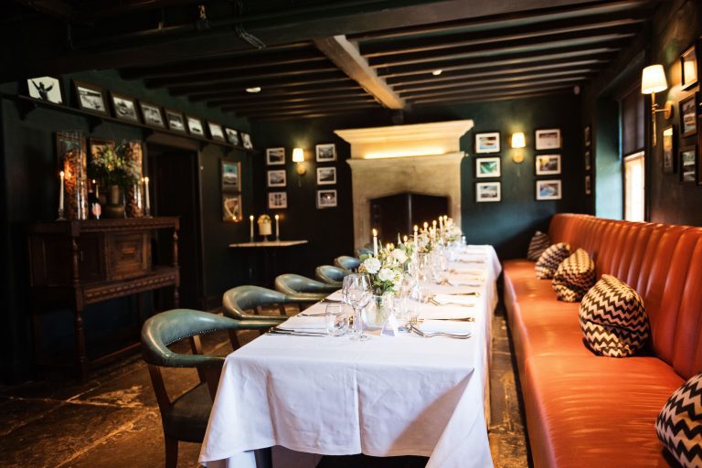 Long table wedding breakfast set up. Candles lit and flowers and wine glasses.