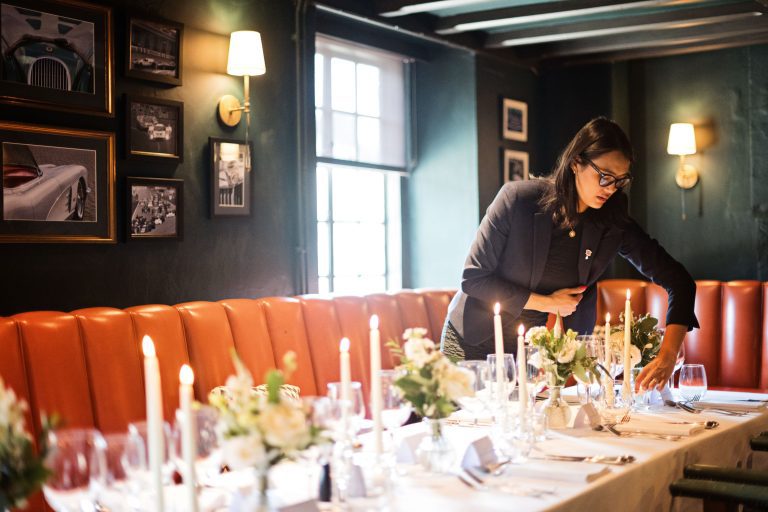 Wedding breakfast set up. Candles being lit by the host.