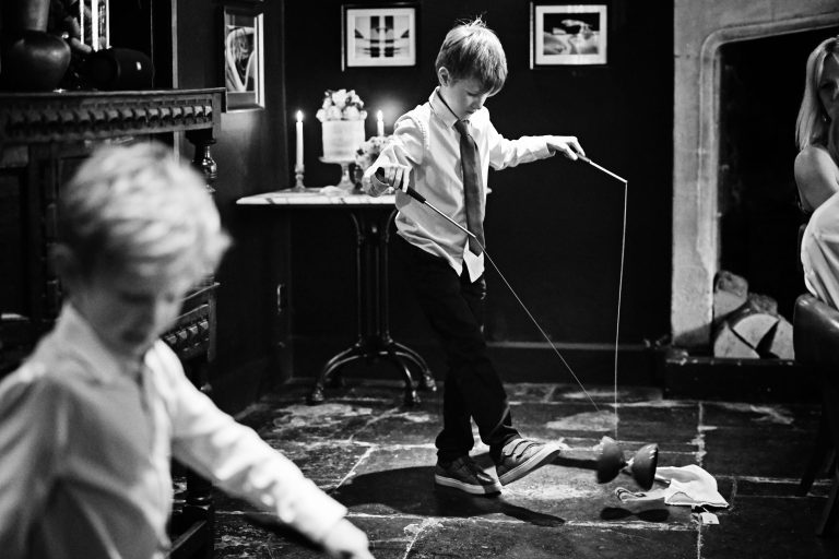 B&W photo of a boy playing with a diabolo during wedding breakfast.