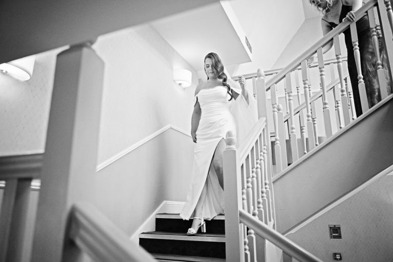 B&W photo of the bride walking down the stairs at The Pear Tree, Purton.