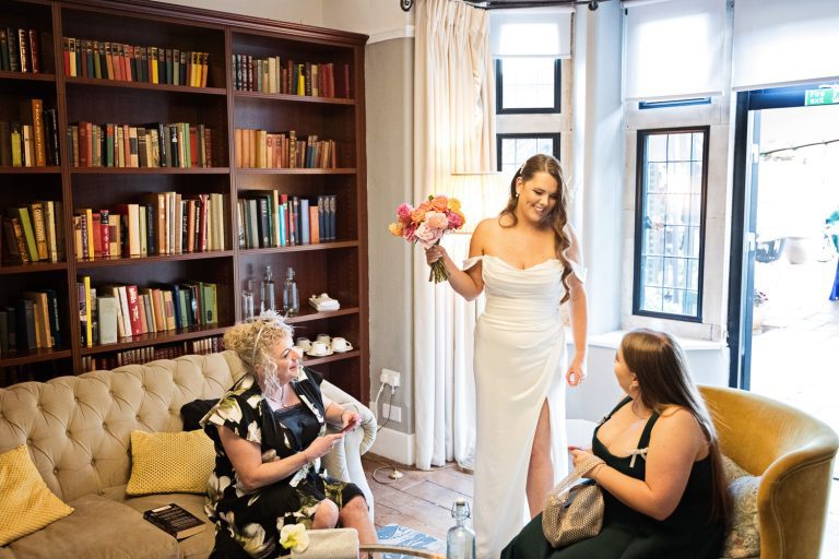 Candid photograph of the bride casually chatting to some wedding guests.