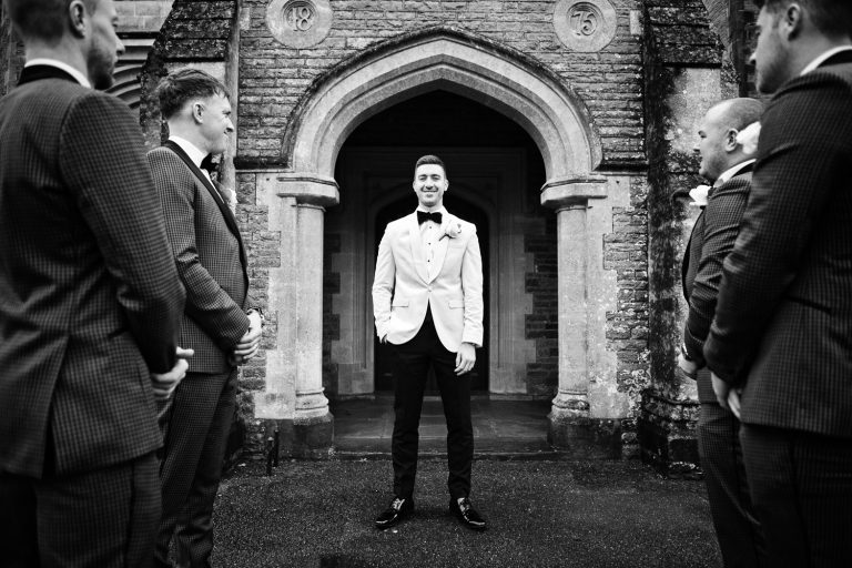 B&W photo of the groom posing with his best men either side of him.