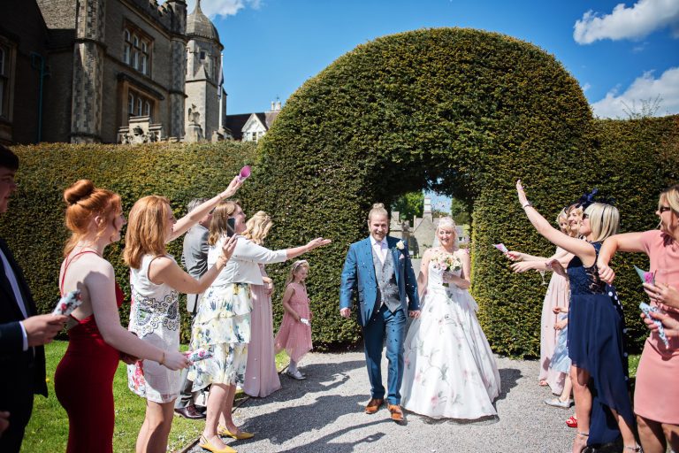 Bride and groom get showered by confetti.
