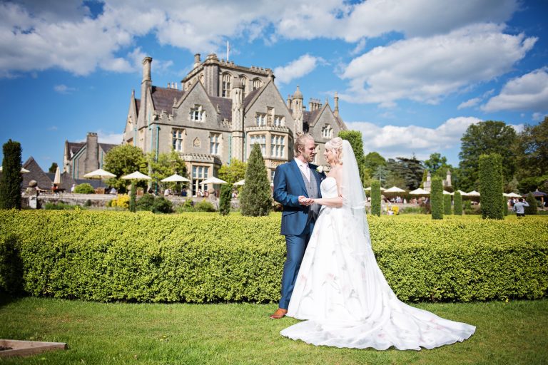 Bride and groom grab a moment together but with Tortworth Court behind them.