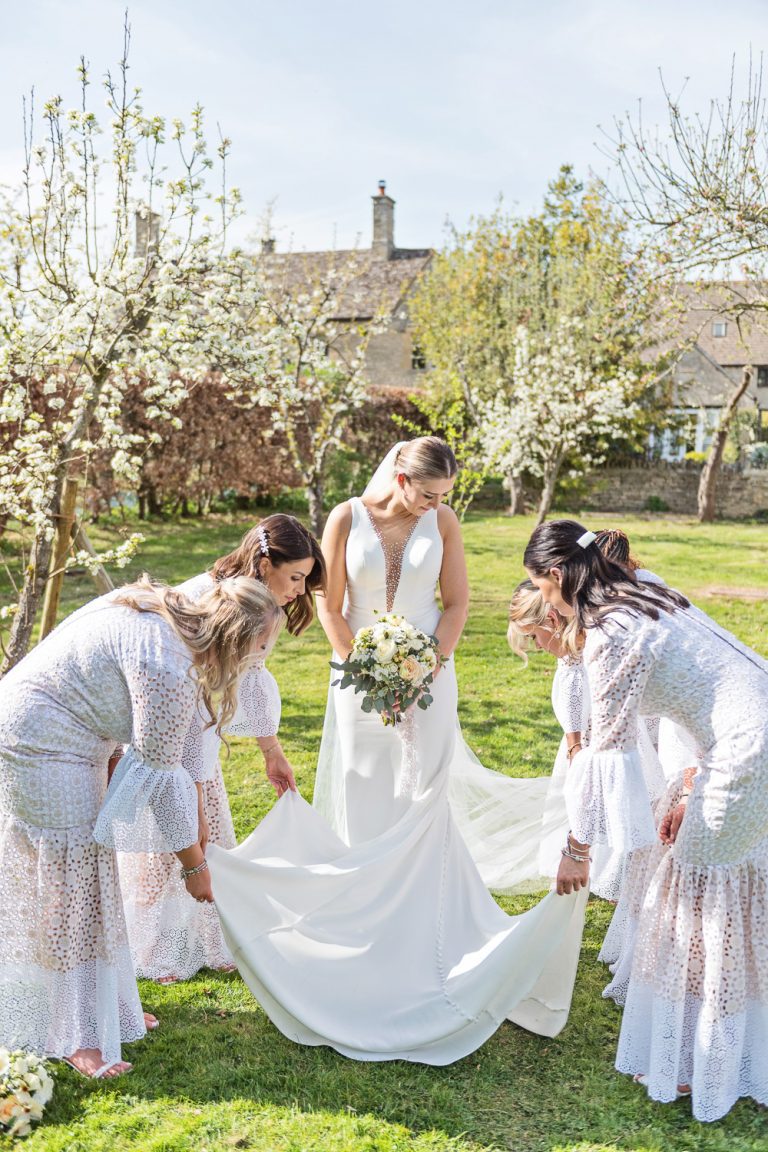 Bridesmaids pull out the brides dress. Looks very pretty.