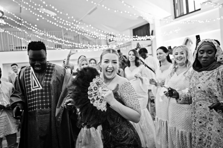 B&W image of bride having fun at her wedding at Worton Hall.