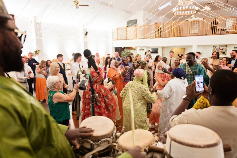 Wedding party dance to the beat of the drums as the party continues at Worton Hall