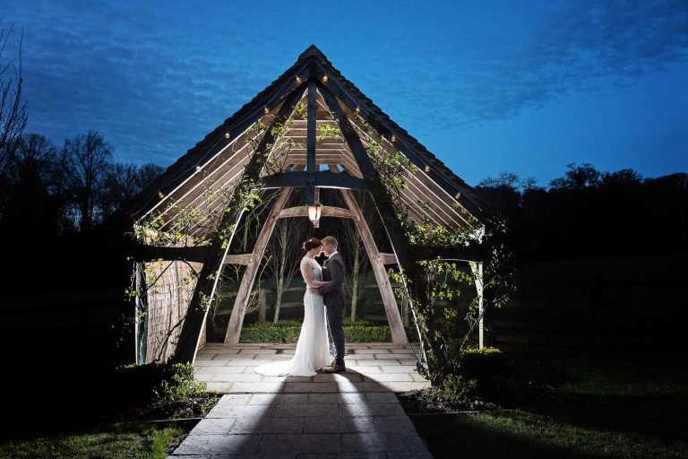 Bride and groom lit up in the arbour at Hyde House.