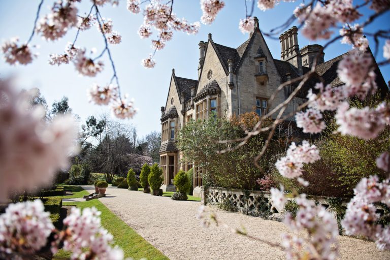 Beautiful photo of Manor By the lake looking though the cherry blossom.
