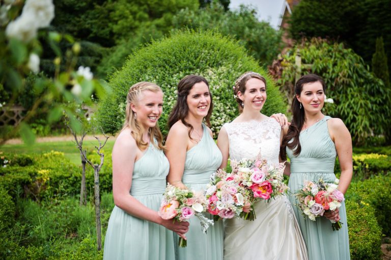 Bridesmaids and bride pose in the formal gardens.