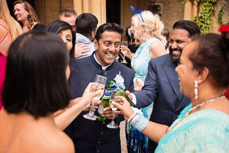 Candid, storytelling photo of guests cheering each other with drinks.