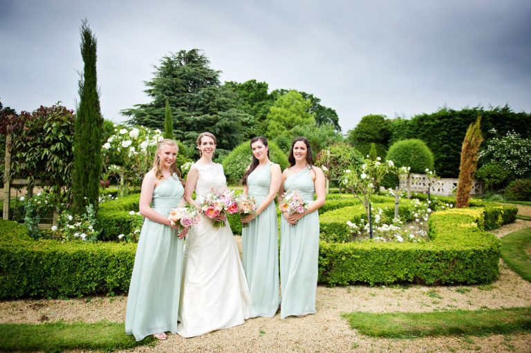 Bridesmaids stand in the gardens at Manor By The Lake.