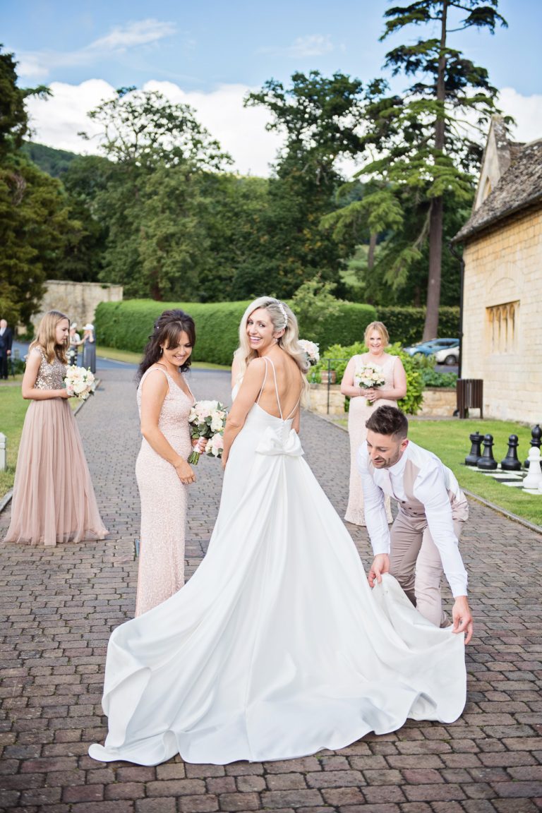 Fun photo of bride and her bridesmaid and man before her Cheltenham wedding