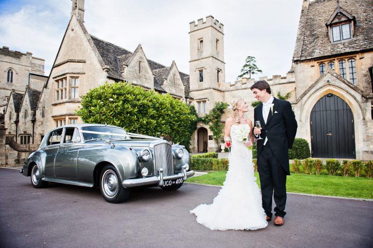 Bride and groom stand out in front of their wedding car and frontage at Cotswold wedding venue, Ellenbough Park