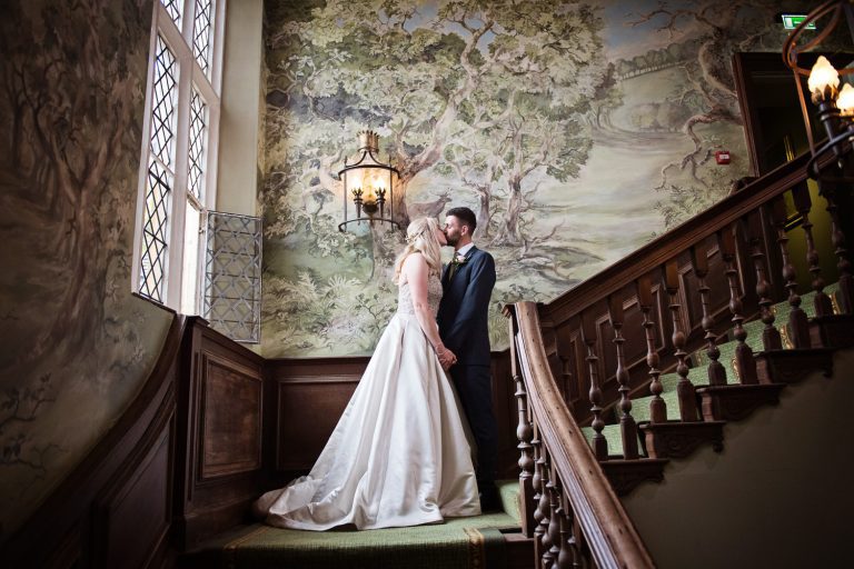 Bride and groom standing on the magnificent staircase at Ellenborough Park.