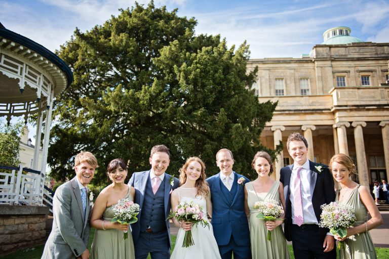 Fun relaxed photo of the bridal party outside the Pittville Pump Rooms and bandstand.