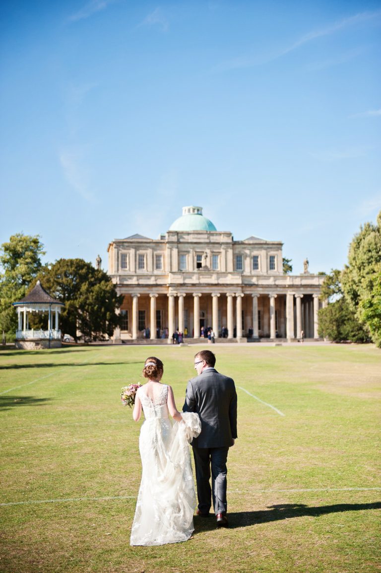 Bride and groom take a moment together as they walk up the lawn towards the Pittville Pump Rooms.
