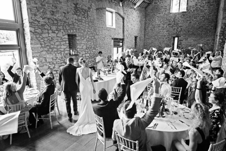 Bride and groom enter the wedding breakfast at Priston Mill.