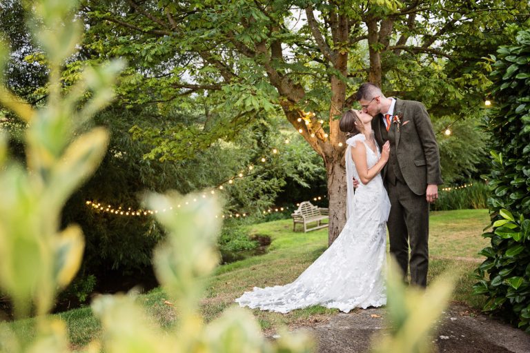 Bride and groom kiss in the evening at Priston Mill.