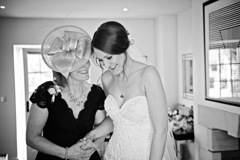 Bride and the brides mum share a moment together, candid B&W photo.