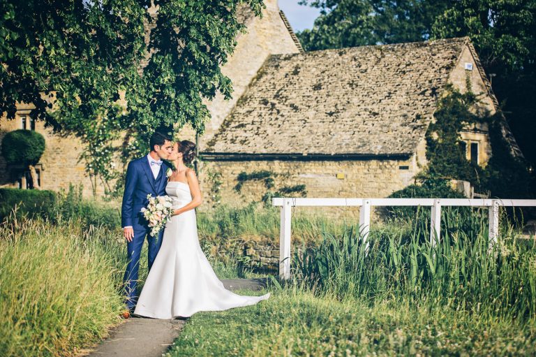 Bride and groom kiss The Slaughters Country Inn