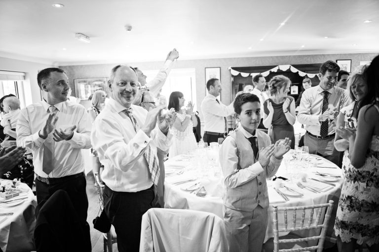 Wedding guests clapping the entrance of the bride and groom at The Slaughters Country Inn