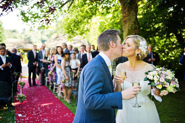 Bride and groom kiss after getting married at The Swan Hotel, Bibury.
