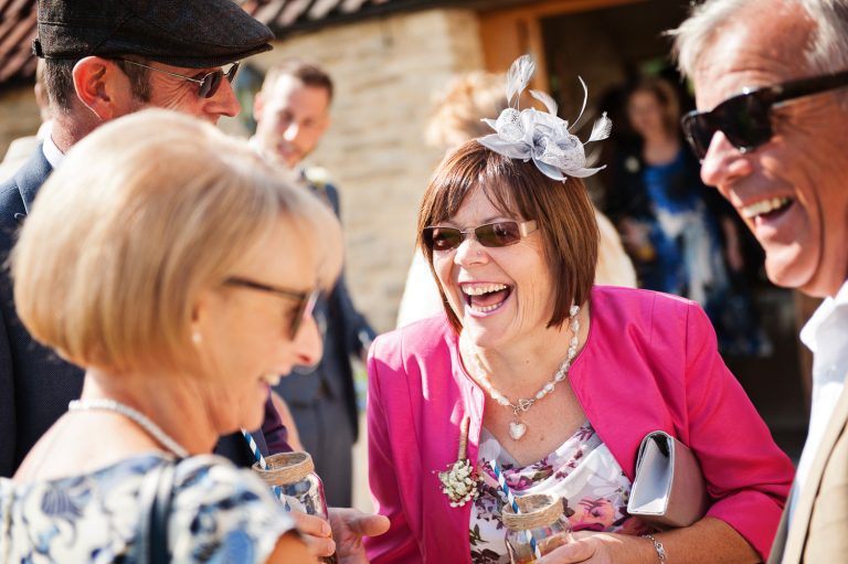 Wedding guests laughing. Natural image.