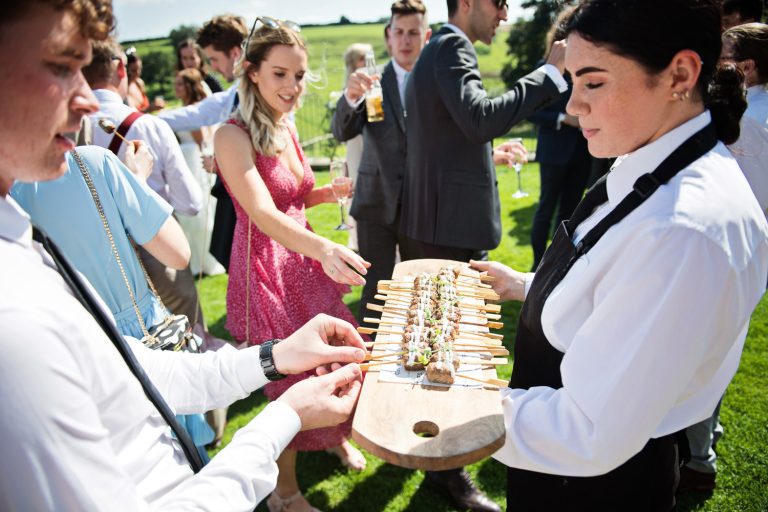 Candid wedding moments of guests helping themselves to canapés.