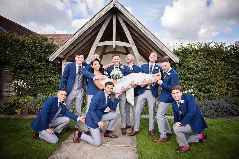 Groomsmen holding up the bride.
