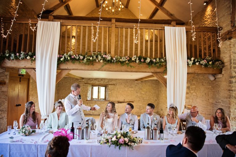 Wedding speeches and the top table at Kingscote Barn.