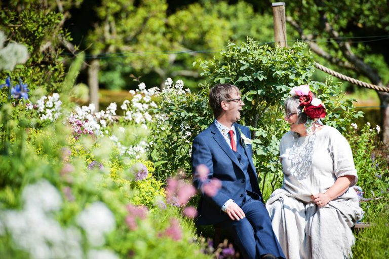 Bride and groom grab a moment together & laughing at the Rococo Gardens, Painswick.