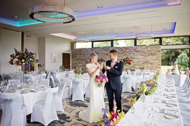 Candid b&W pic of bride and groom enjoying a moment in the Cotswold Suite at Tewkesbury Park.