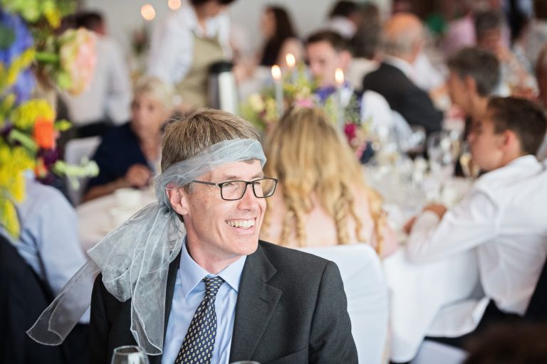 Documentary photo of wedding guests enjoying themselves at Tewkesbury Park in the Cotswold Suite.