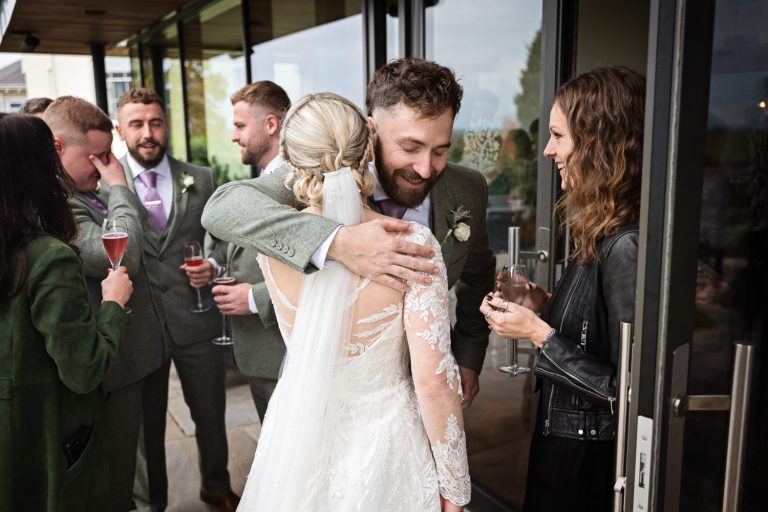 Documentary image of wedding guests congratulating the bride at Tewkesbury Park