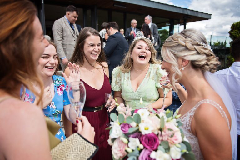 Documentary image of wedding guests congratulating the bride at Tewkesbury Park Hotel