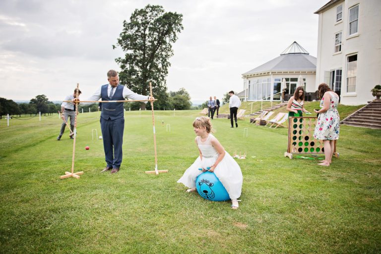 Story telling image of wedding guests playing at Tewkesbury Park