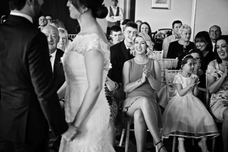 Candid moment of guests congratulating the bride and groom getting married at Tewkesbury Park