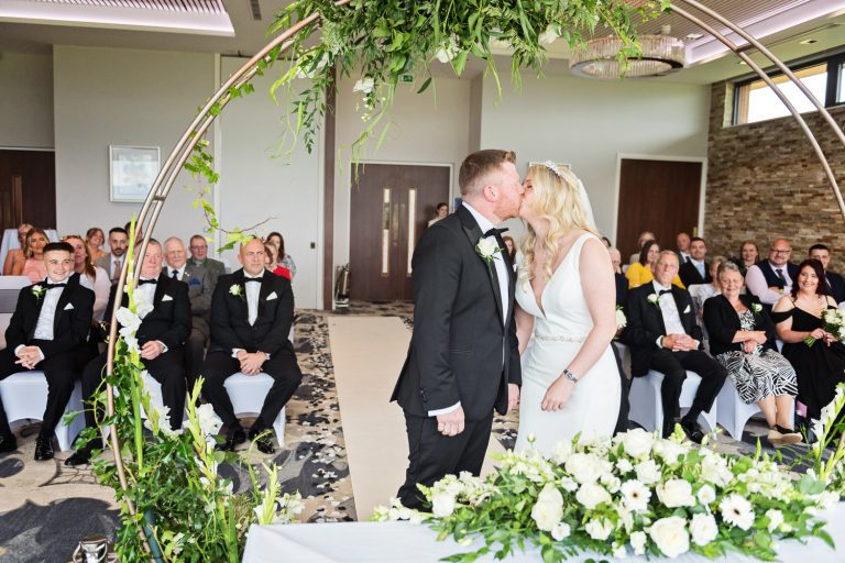 Bride and groom kiss after being announced husband and wife at a wedding at Tewkesbury Park