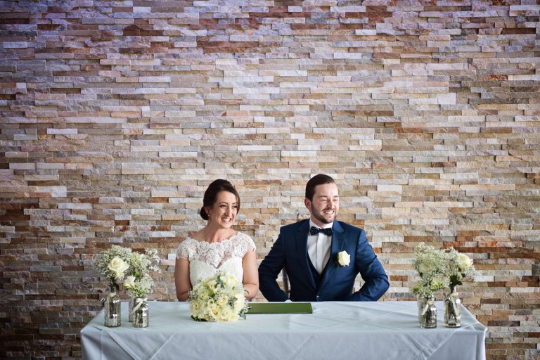 Bride and groom signing the registry at a wedding at Tewkesbury Park