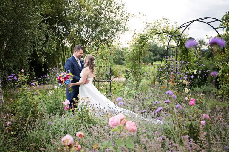 Bride and groom grab a moment in the gorgeous gardens at Tewkesbury Park.