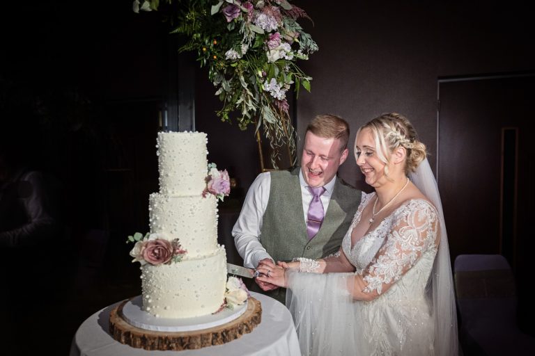 Bride and groom cut their wedding cake at Tewkesbury Park