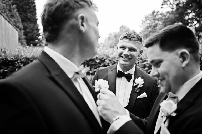 B&W candid photo of the groom looking on at his best men.