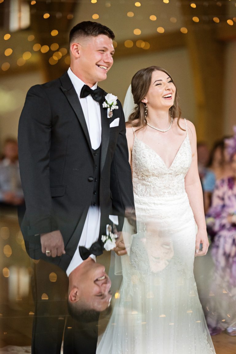 Portrait photo of the bride and groom smiling as they get married.