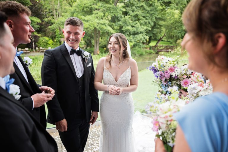 Bride and groom chatting to their wedding guests all smiling.