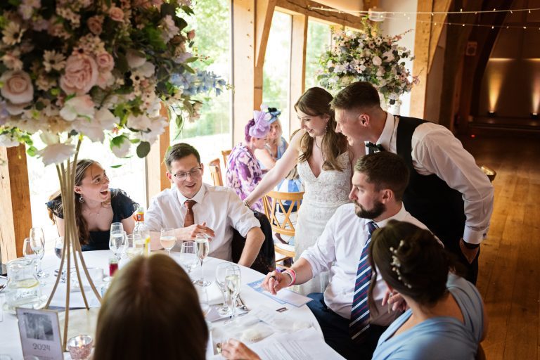 Bride and groom naturally chatting to their wedding guests during the wedding breakfast.