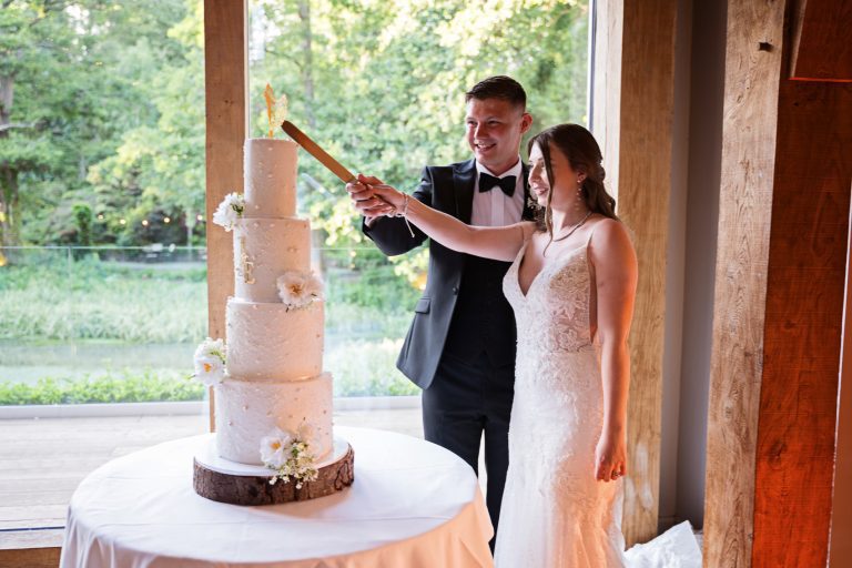 Bride and groom about to cut their 4 tiered wedding cake.